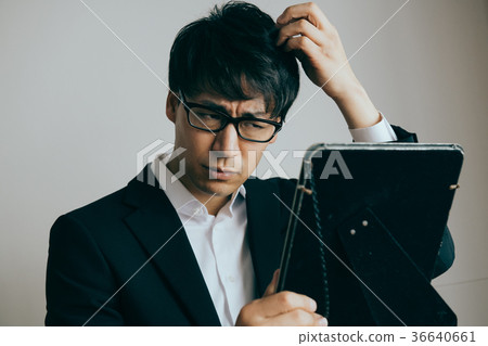 Young male businessman minding hair 36640661