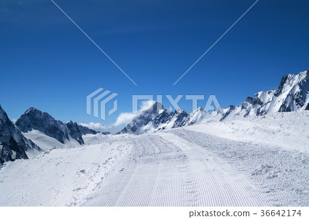 Snowy road with trace from snow groomer  36642174