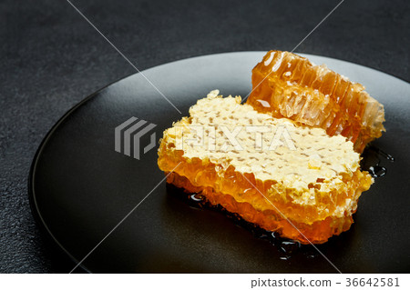 Honeycomb with honey on plate. dark concrete Honeycomb with honey on plate. dark concrete 36642581
