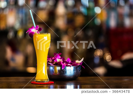 Yellow cocktail with orchid flower in the bar 36643478