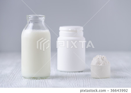 glass bottle of milk and powder on gray background 36643992