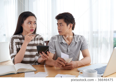Unhappy Young Family Calculating Expenses 36646475