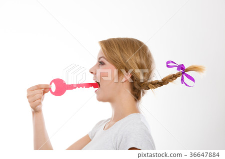 Teenage girl with braid biting key Teenage girl with braid biting key 36647884