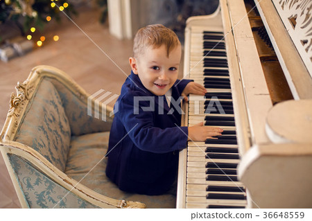 little boy in costume sitting on the chair 36648559