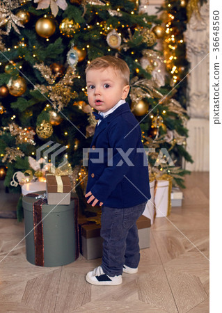 baby boy stands in a suit at Christmas at 36648560