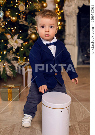 baby boy stands in a suit at Christmas at 36648562