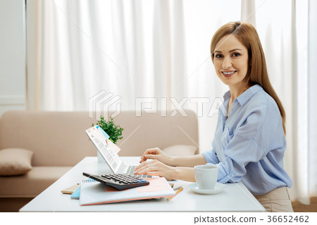 Cheerful young woman working on her laptop 36652462