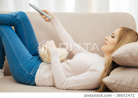 Smiling young woman lying on the sofa Smiling young woman lying on the sofa 36652472