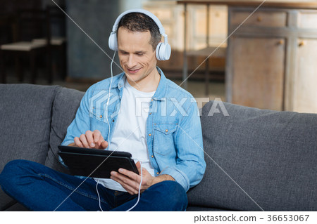 Relaxed brunette playing with his gadget 36653067