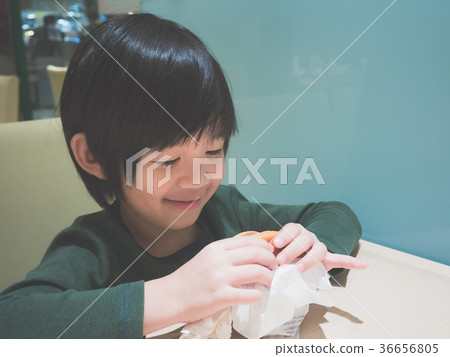 Asian girl in eating a hamburger in the restaurant 36656805