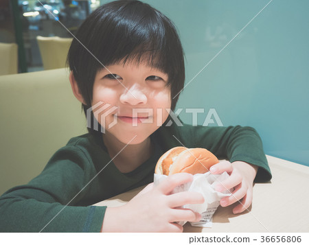Asian girl in eating a hamburger in the restaurant Asian girl in eating a hamburger in the restaurant 36656806