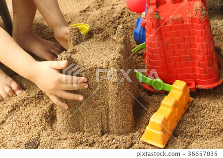 Close up of a child's hand playing sand toys. 36657035