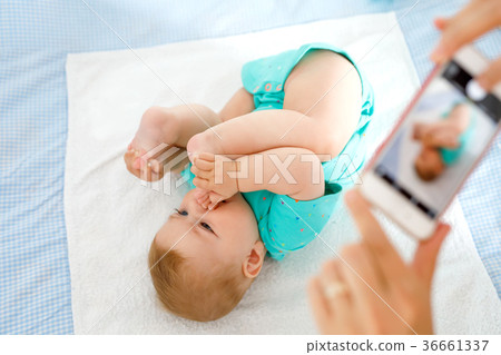 Parent taking photo of a baby with smartphone Parent taking photo of a baby with smartphone 36661337