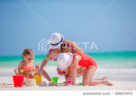 Mother and two kids playing with sand on tropical Mother and two kids playing with sand on tropical 36663041