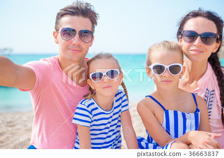 Young beautiful family taking selfie on the beach 36663837