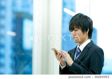Businessman operating a smartphone New employee New employee Young employee Business image 36664993