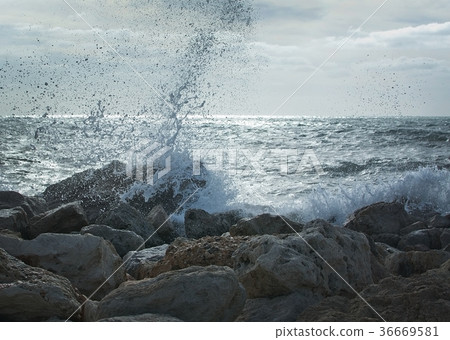 Waves splash onto rocks 36669581