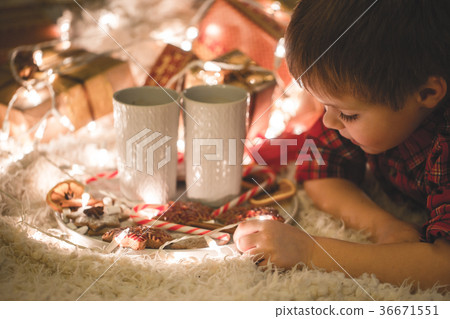 Boy laying under christmas tree with chocolate 36671551
