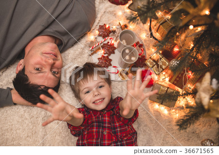 Father and son laying under christmas tree. 36671565