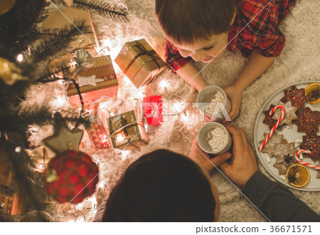Father and son laying under christmas tree. 36671571