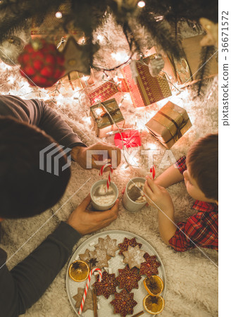 Father and son laying under christmas tree. 36671572