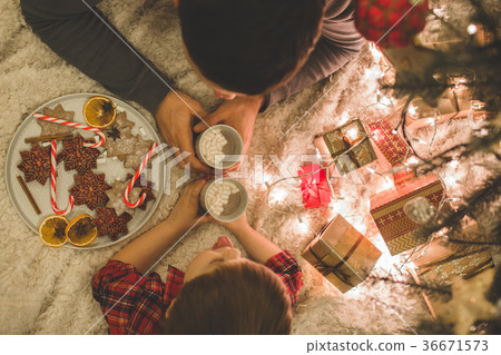 Father and son laying under christmas tree. 36671573