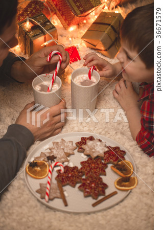 Father and son laying under christmas tree. 36671579