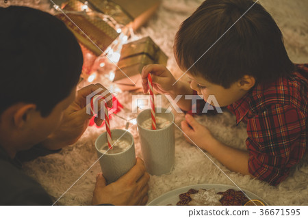 Father and son laying under christmas tree. 36671595