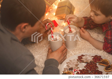 Father and son laying under christmas tree. 36671597