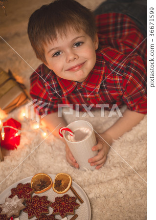 Boy laying under christmas tree with chocolate 36671599