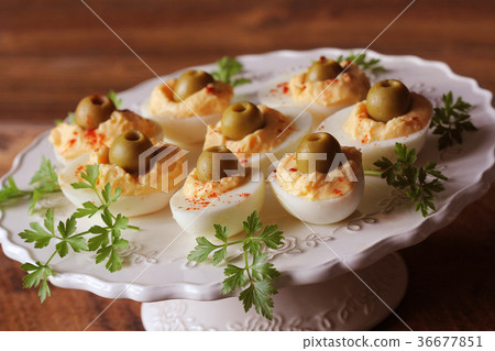 Spicy deviled eggs garnished with green olives Spicy deviled eggs garnished with green olives 36677851