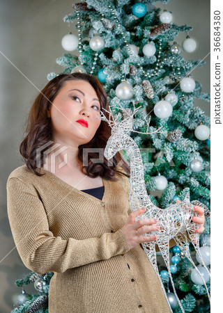 asian woman with reindeer toy in her arms asian woman with reindeer toy in her arms 36684380