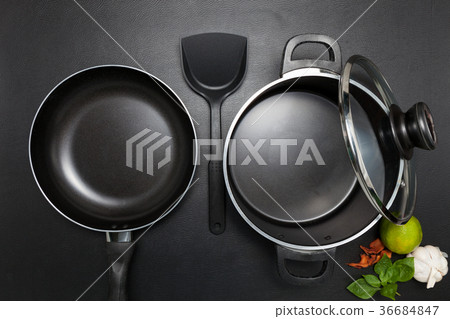 Top view frying pan and pot on black table. Top view frying pan and pot on black table. 36684847