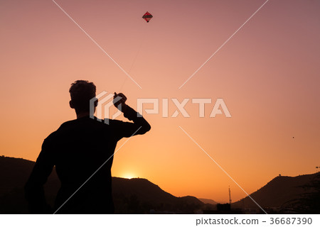 Young boy playing with kite at sunset Young boy playing with kite at sunset 36687390