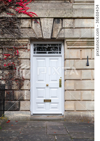 Door in stone wall with climbing plant 36688434
