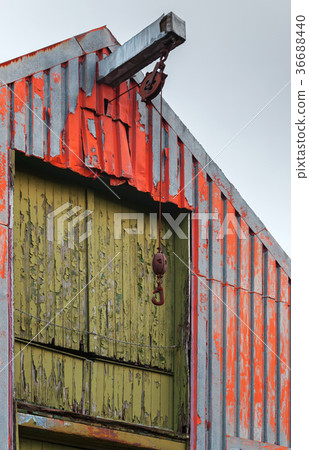 Old hangar with rusted manual crane hook Old hangar with rusted manual crane hook 36688440