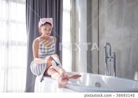 Beautiful girl shaving leg hair by razor 36693148