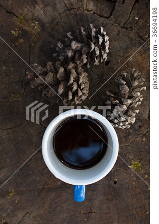 Blue cup of coffee on log 36694198