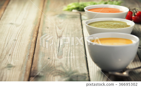 Variety of cream soups over old wood background Variety of cream soups over old wood background 36695302