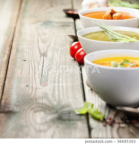 Variety of cream soups over old wood background Variety of cream soups over old wood background 36695303