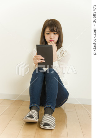 一個女人困擾著看著一台平板電腦 36695475