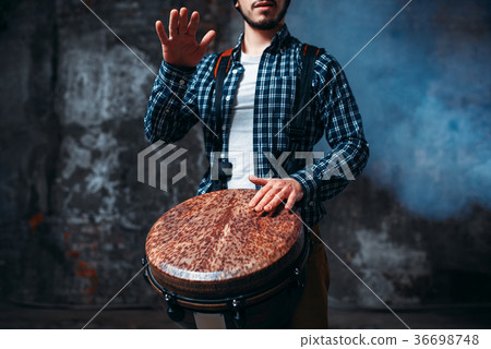 Male drummer playing on wooden drum 36698748