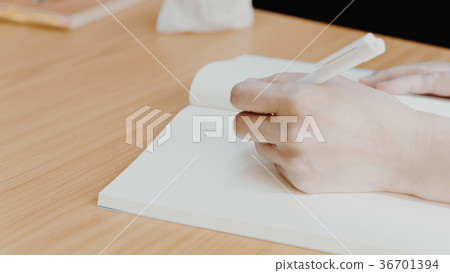 Hand of woman holding a pen for write to a book 36701394