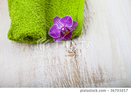 Green towel and orchid close-up. 36703857
