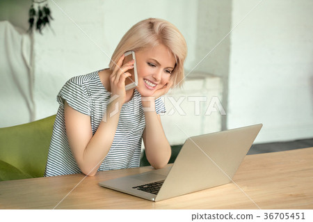 Girl working on computer and talking phone Girl working on computer and talking phone 36705451