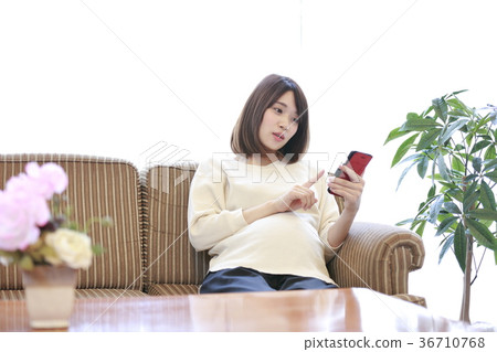 Maternity woman sitting on couch Maternity woman sitting on couch 36710768