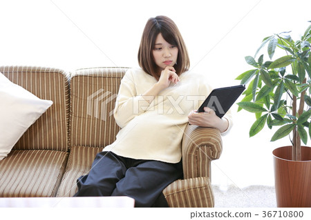 Maternity woman sitting on couch 36710800
