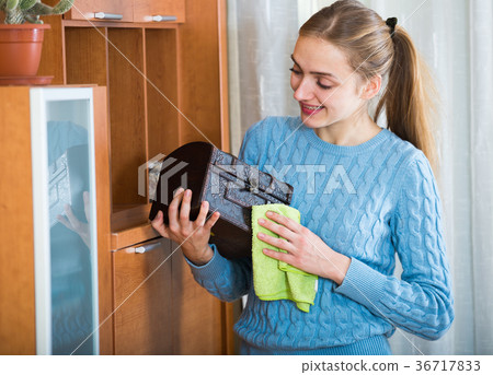 Cheerful girl in blue jersey cleaning at home 36717833