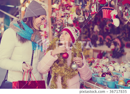 smiling mother with little daughter buying decorations for Xmas 36717835