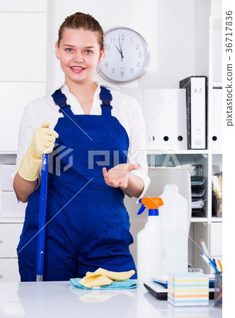 Cleaner female is talking while cleaning the cabinet 36717836